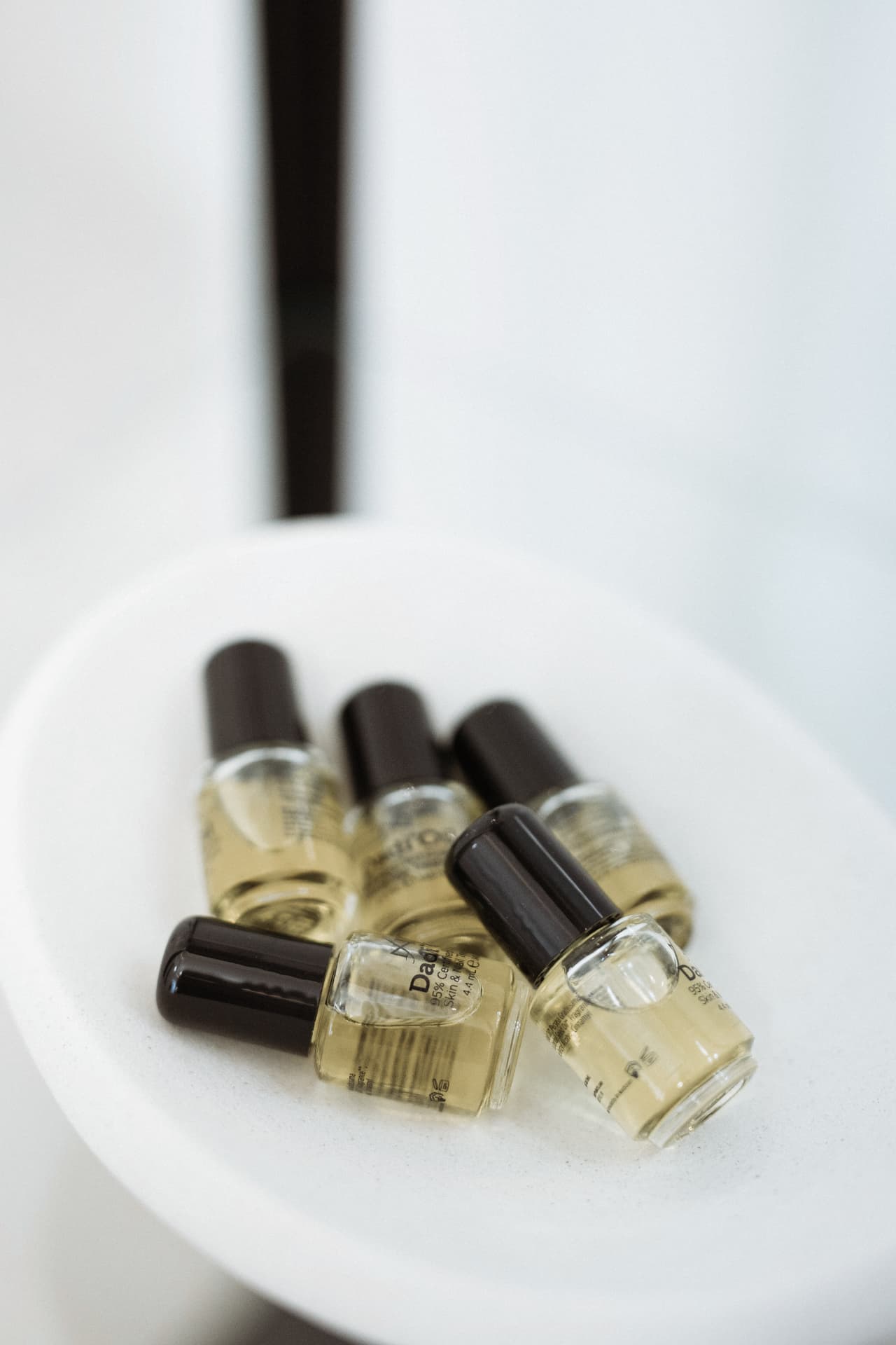 Small bottles of Footlogix Dadi’ Oil arranged in a white bowl