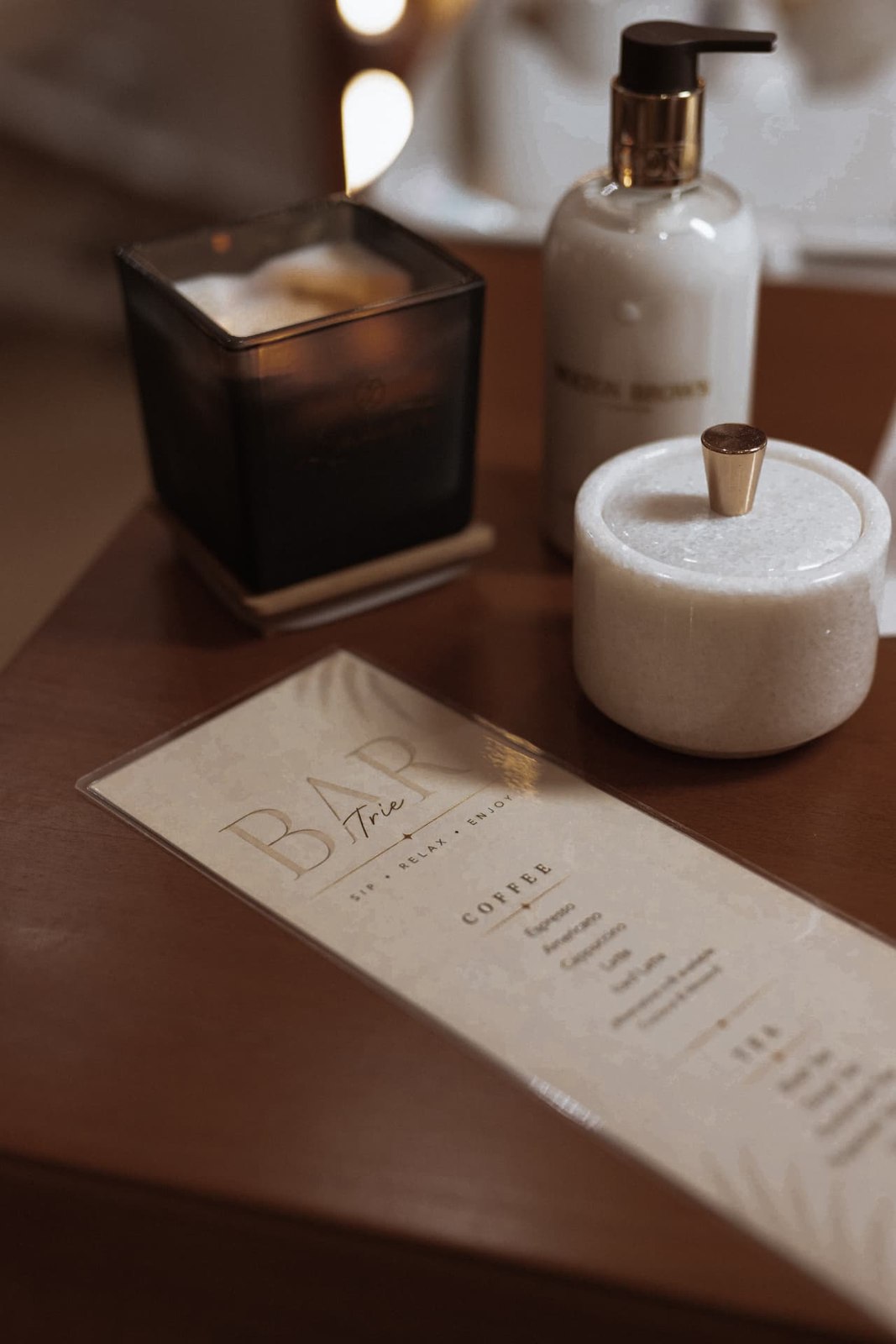 The TRIÉ drinks menu beside a candle and salon details